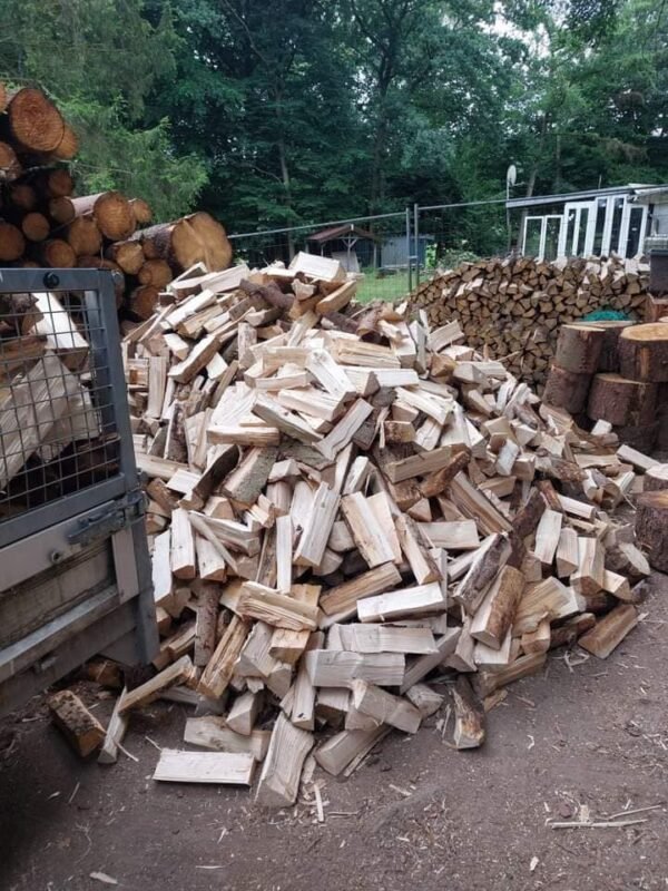 Pile de bois de chauffage coupé en bûches, prêtes pour être utilisées dans une cheminée ou un poêle.